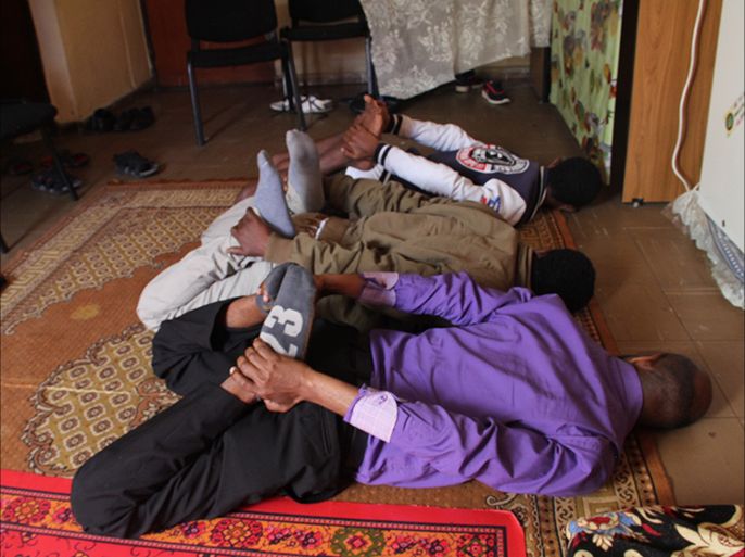 سجناء إريتريون سابقون يحاكون واحدة من أوضاع التعذيب التي مورست بحقهم