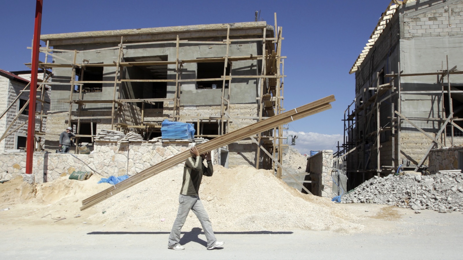 عامل فلسطيني في موقع للبناء في مستوطنة كيدار اليهودية بالضفة الغربية (رويترز)