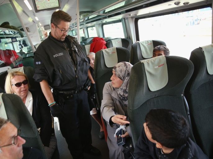FREILASSING, GERMANY - SEPTEMBER 15: A policeman questions passengers and asks migrants without a valid visa to disembark from a regular train that had arrived from Vienna, Austria, on September 15, 2015 in Freilassing, Germany. German authorities have temporarily reinstated border controls along Germany's border to Austria and are using Freilassing as a hub for managing migrants arriving by train from Austria and the Balkans. Germany is still accepting up to thousands of new migrants daily but has imposed border controls in order to crack down on smugglers and to better regulate the flow of arriving migrants, tens of thousands of whom arrived in Germany over the last few weeks. Meanwhile Hungary has sealed it new fence along its border to Serbia and is ferrying remaining migrants to izs border with Austria. (Photo by Sean Gallup/Getty Images)