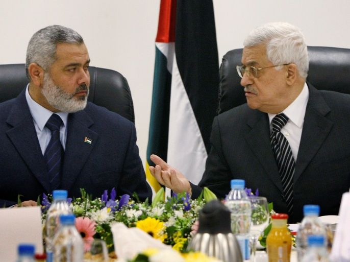 FILE PHOTO: Palestinian President Mahmoud Abbas (R) talks with Prime Minister Ismail Haniyeh during the first cabinet meeting of the Palestinian unity government in Gaza March 18, 2007. REUTERS/Suhaib Salem/File Photo