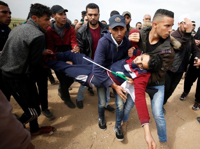 A wounded Palestinian is evacuated during clashes with Israeli troops during a tent city protest along the Israel border with Gaza, demanding the right to return to their homeland, east of Gaza City March 30, 2018. REUTERS/Mohammed Salem