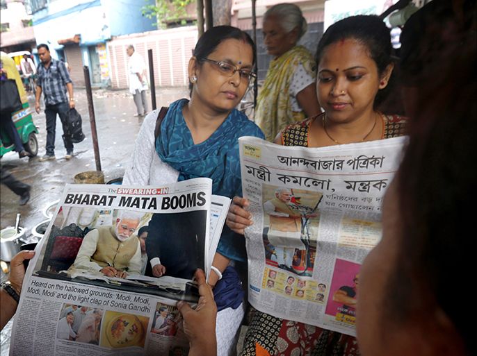 epa04227445 Indian women read newspapers with frontpage headlines and reports about India's new Prime Minister Narendra Modi at a small street bistro in Calcutta, Eastern India, 27 May 2014. Narendra Modi on 26 May was sworn in as India's 15th Prime minister vowing to build a 'glorious future' for the South Asian country. Modi on his first day in office was already scheduled to met with Afghan President Hamid Karzai and due to meet eight other regional leaders who attended his inauguration, according to the Ministry of External Affairs. EPA/PIYAL ADHIKARY