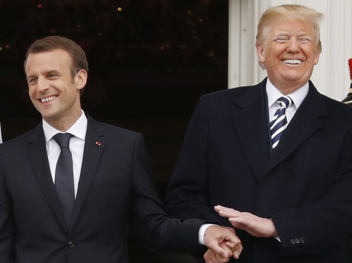 U.S. President Donald Trump laughs as he holds hands with French President Emmanuel Macron during the official arrival ceremony for Macron on the South Lawn of the White House in Washington, U.S., April 24, 2018. REUTERS/Jonathan Ernst