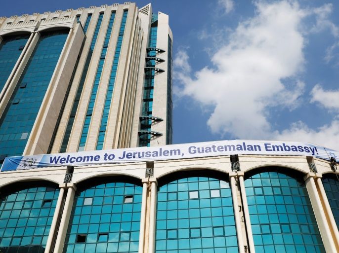Workers hanging from the side of a building place a banner welcoming the opening of the new Guatemalan embassy in Jerusalem, in the complex hosting the new embassy in Jerusalem, May 15, 2018. Picture taken May 15, 2018. REUTERS/Ronen Zvulun