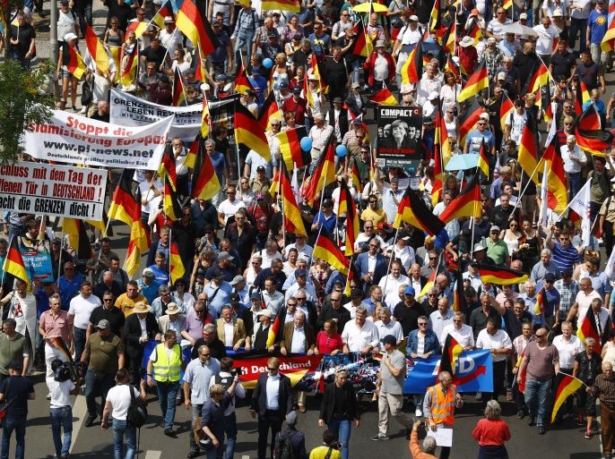 Supporters of the Anti-immigration party Alternative for Germany (AfD) hold German flags during a protest in Berlin, Germany May 27, 2018. REUTERS/Hannibal Hanschke