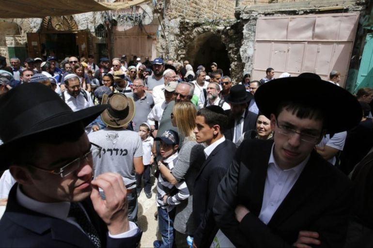 epa05906072 Israeli settlers and Jewish visitors walk in the old market during a tour on the Passover holiday in the old city of the West Bank of Hebron, 13 April 2017. Thousands of Israeli settlers spent the day outdoors, picnicking and visiting holy sites in the occupied West Bank as they continue to celebrate the eight-day holiday, which commemorates the Israelites' exodus from Egypt some 3,500 years ago. EPA/ABED AL HASHLAMOUN