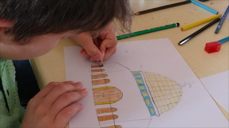 طفل يرسم قبة الصخرة في فعالية أيام الأقصى للرسم