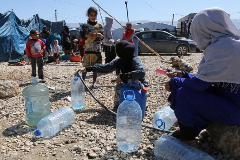 Syrian refugees fill containers and bottles with water at a makeshift settlement in Bar Elias town, in the Bekaa valley, Lebanon March 28, 2017. Picture taken March 28, 2017. REUTERS/Aziz Taher
