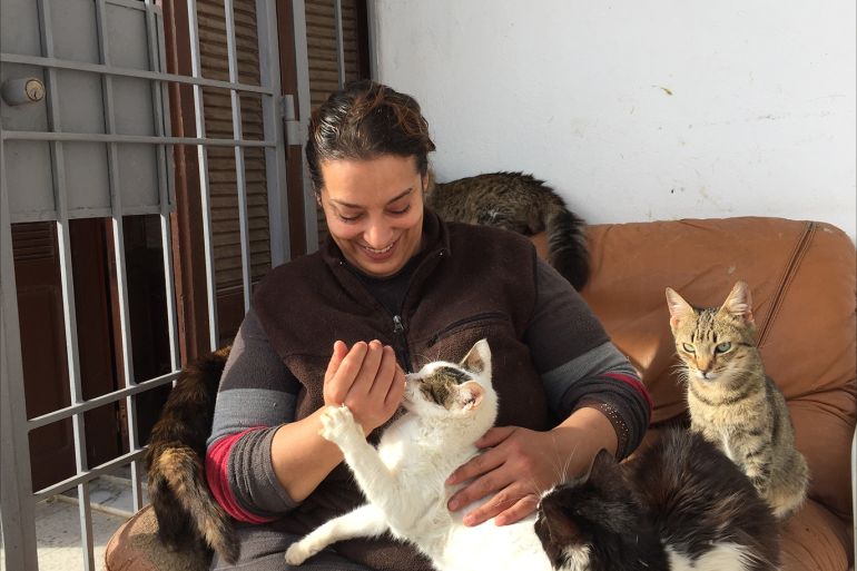 هدى بوشهدة عاشقة القطط والكلاب بتونس تحتضن إحدى قططها وسط عشرات من حيواناتها الأليفة