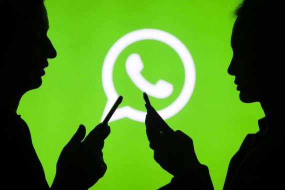 Digital Applications- - ANKARA, TURKEY - JULY 18 : Silhouettes of people holding mobile phones in front of the logo of WhatsApp application in Ankara, Turkey on July 18, 2018.