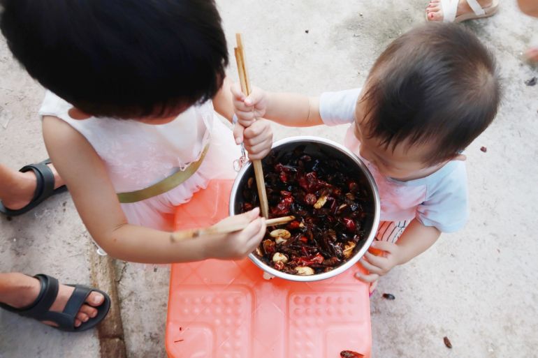 Children of cockroach farm owner Li Bingcai eat fried cockroaches at his farm in a village in Changning county, Sichuan province, China August 11, 2018. Picture taken August 11, 2018. REUTERS/Thomas Suen