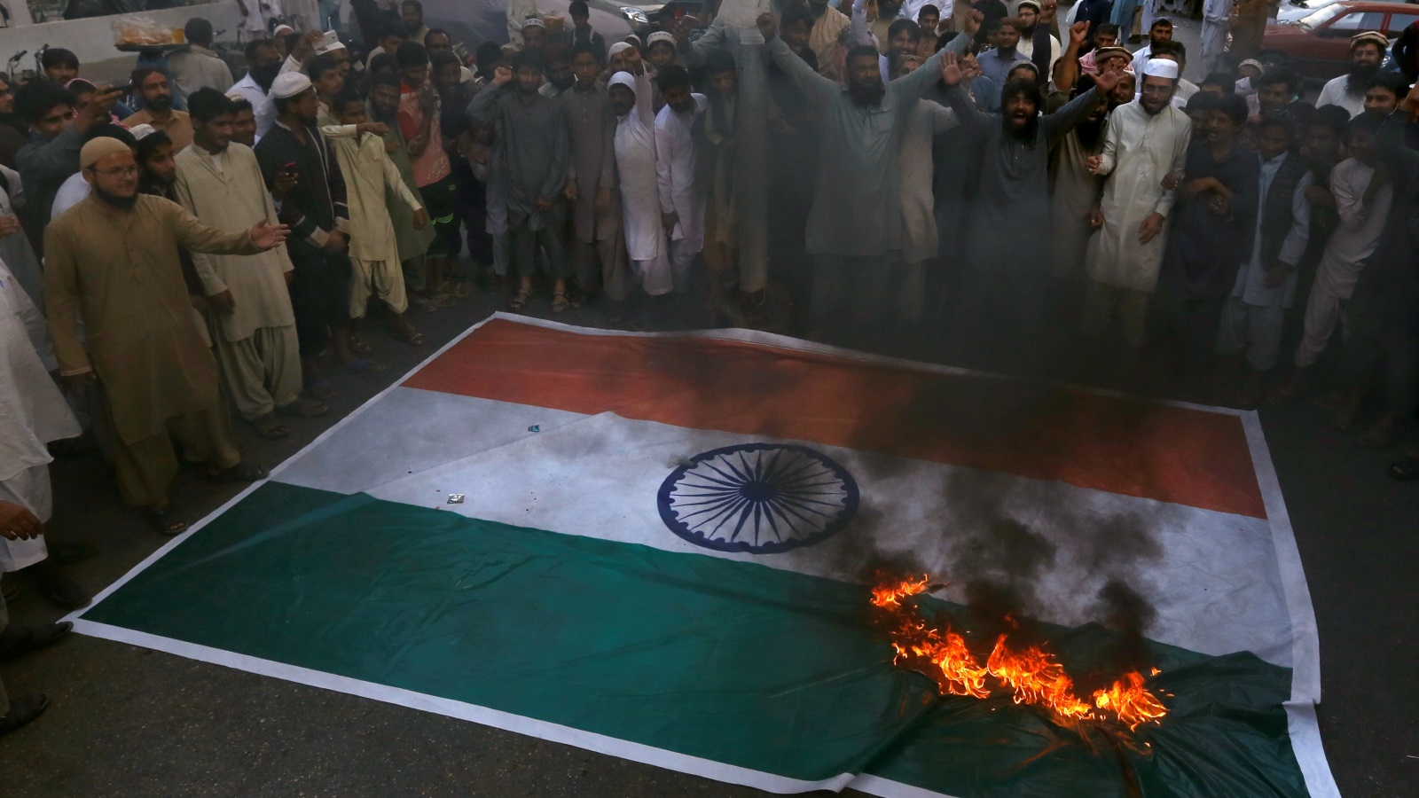 محتجون كشميريون يحرقون العلم الهندي (رويترز)