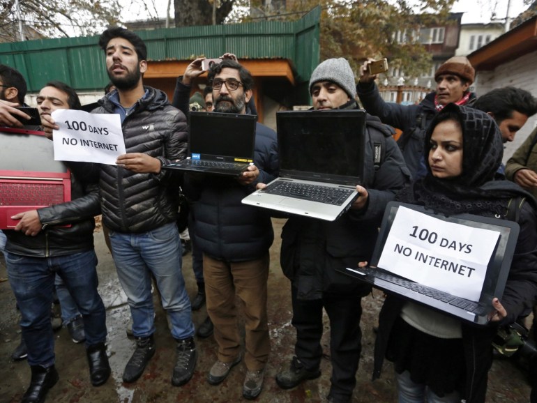 Kashmiri journalists display laptops and placards during a protest demanding restoration of internet service, in Srinagar, November 12, 2019. REUTERS/Danish Ismail