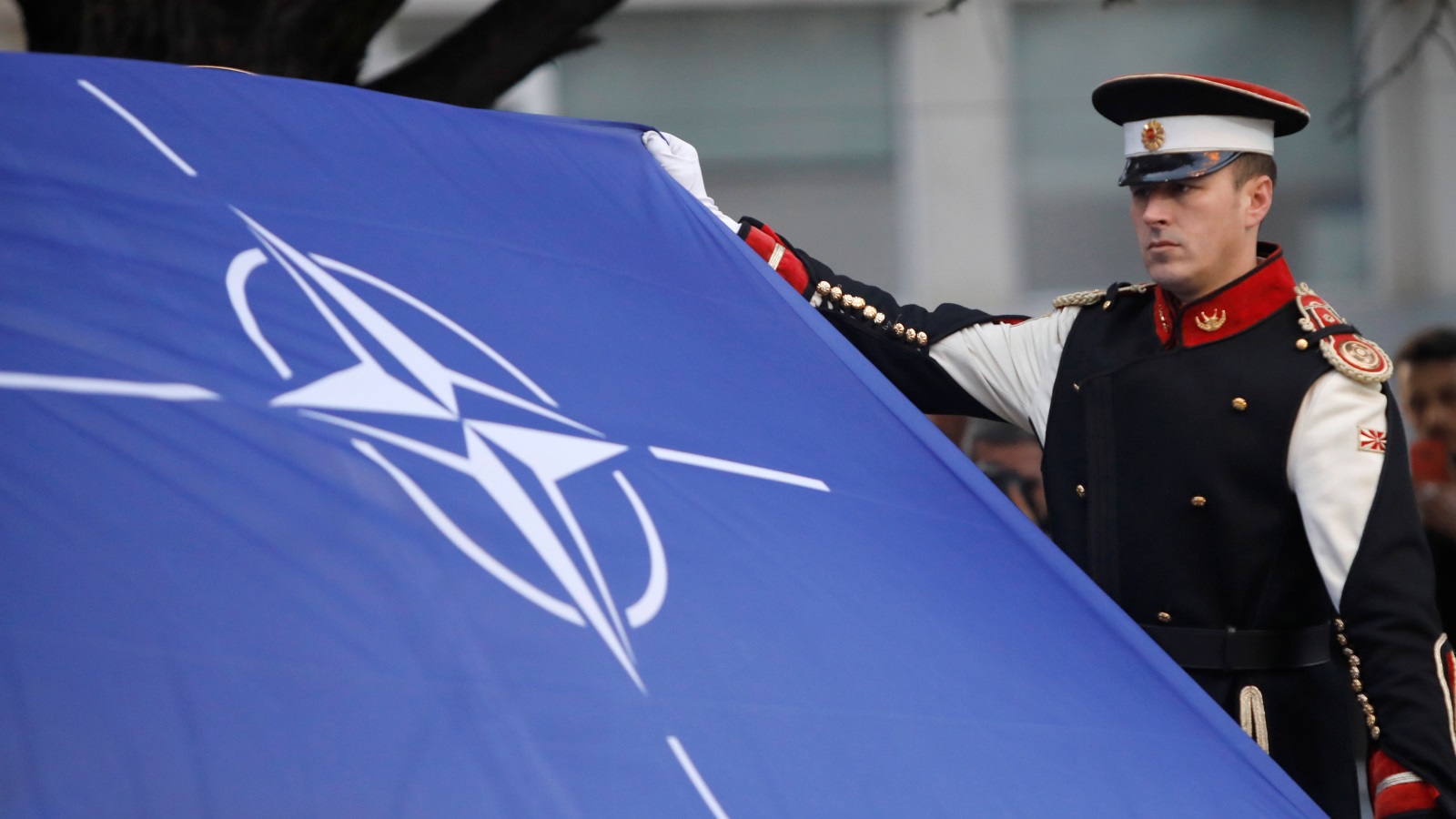 ‪(رويترز)‬ علم الناتو أمام مبنى البرلمان المقدوني