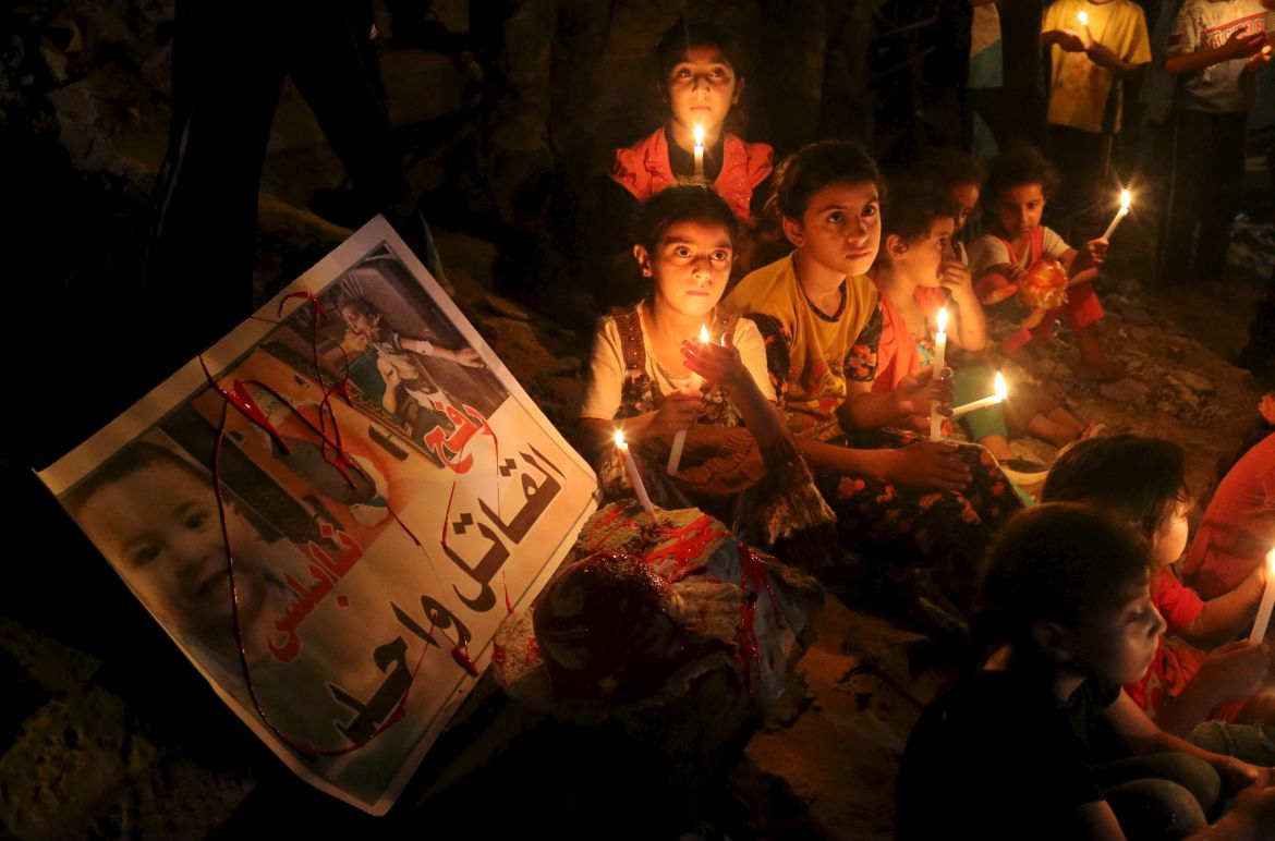 Palestinian children light candles during a rally to remember 18-month-old Palestinian baby Ali Dawabsheh who was killed after his family's house was set on fire in a suspected attack by Jewish extremists in Rafah in the southern Gaza Strip