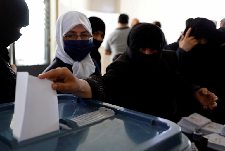 A woman casts her vote inside a polling station during the parliamentary elections in Douma