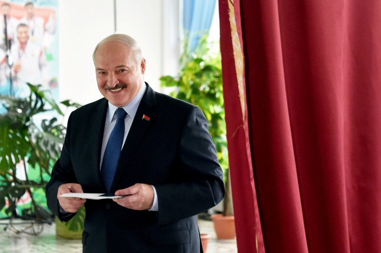 Belarusian President Alexander Lukashenko visits a polling station during the presidential election in Minsk