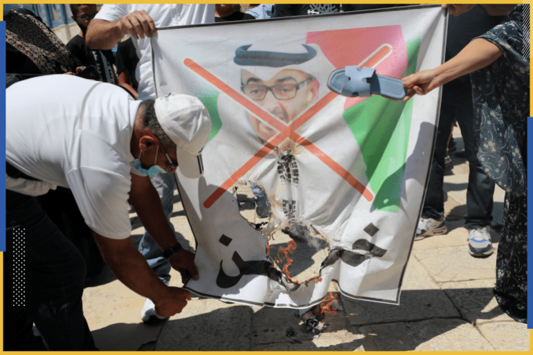 A man burns a poster depicting Abu Dhabi Crown Prince Mohammed bin Zayed al-Nahyan during a protest against the United Arab Emirates, in Jerusalem's Old City, August 14, 2020. REUTERS/Ammar Awad