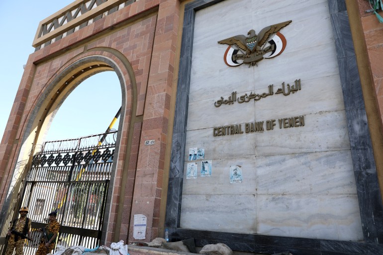 Guards stand at the gate of the Central Bank of Yemen in Sanaa