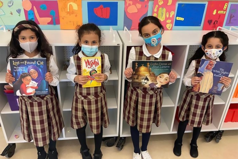 مجموعة من الطالبات يحملن الكتب التي تبرعت بها زينة ومينا