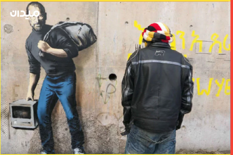 غرافيتي شهير لدعم اللاجئين يظهر ستيف جوبز يحمل حقيبة كأنه مهاجر/لاجئ، في إشارة إلى أن المهاجرين قد يُشكّلون العالم للأفضل (مواقع التواصل)