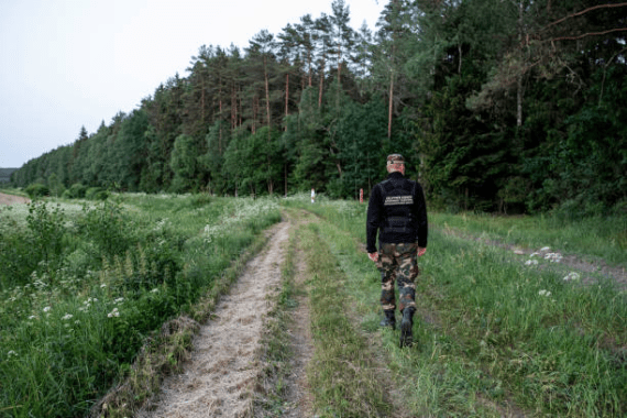 POSKONYS, LITHUANIA - JUNE 21: Lithuania State Border guard Eimantas Smolenskas patrols near the Lithuania-Belarus border line on June 21, 2021 near Poskonys, Lithuania. The Lithuanian government has accused the President of Belarus, Alexander Lukashenko, of illegally allowing refugees from the Middle East trying to reach Europe to pass through its borders. Lithuanian foreign minister Gabrielius Landsbergis said the Belarusian leader is using migration as a weapon against the European Union, which has adopted sanctions against him and the nation. (Photo by Paulius Peleckis/Getty Images)