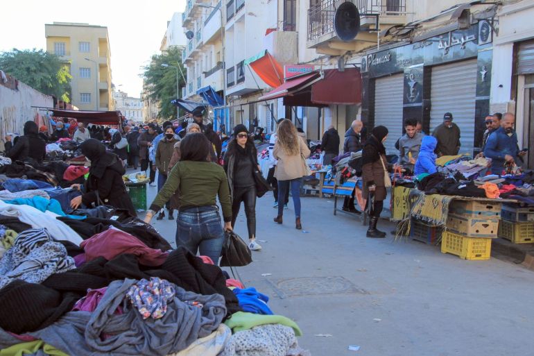 © DPA (Arabic) أناس يمشون في سوق ملابس قديمة في تونس العاصمة. Cindy Riechau/dpa