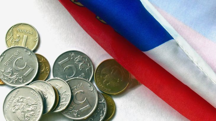 Russian coins on the background of the Russian flag روبيل وعلم روسيا غيتي
