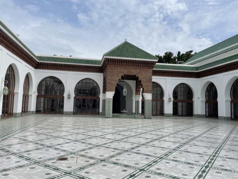 صحن مسجد السنة فضاء جميل مفتوح وتظهر واحدة من النافورات وأسقف القرميد الخضراء