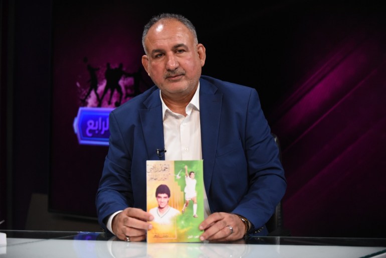 المؤلف مع كتابه عن الراحل أحمد راضي (الجزيرة نت)
