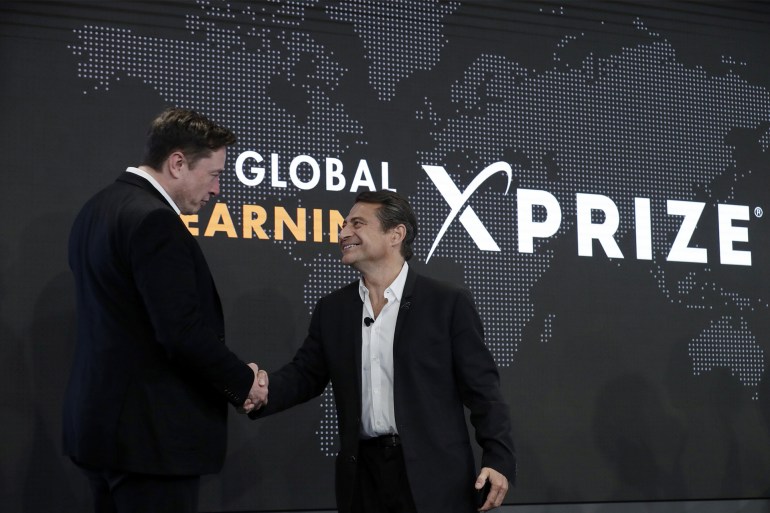 Tesla CEO Elon Musk, left, shakes hands with XPRIZE founder and Executive Chairman Peter Diamandis during the presentation of the XPRIZE for Children's Literacy in Los Angeles, in this Wednesday, May 15, 2019, file photo. Organizers of a $20 million contest to develop products from greenhouse gas that flows from power plants announced two winners Monday, April 19, 2021, ahead of launching a similar but much bigger competition backed by Elon Musk. Both winners made concrete that trapped carbon dioxide, keeping it out of the atmosphere, where it can contribute to climate change. Production of cement, concrete's key ingredient, accounts for 7% of global emissions of the greenhouse gas, said Marcius Extavour, XPRIZE vice president of climate and energy.(AP Photo/Marcio Jose Sanchez, File)