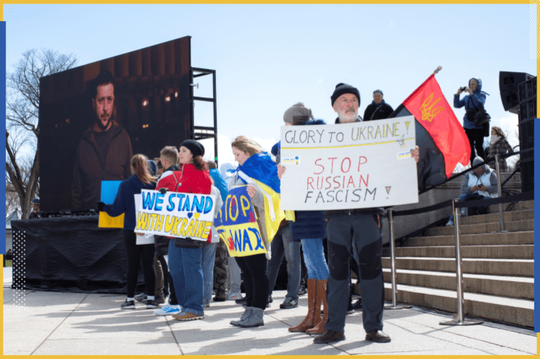 Pro-Ukrainian demonstrators display signs of protest as a pre-recorded video featuring Ukraine President Volodymyr Zelenskyy is played during a “Stand with Ukraine” rally at the Lincoln Memorial on the National Mall in Washington, U.S., March 27, 2022. REUTERS/Tom Brenner