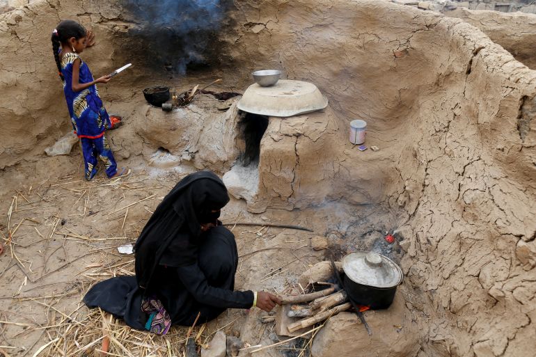 Afaf Hussein (L), 10, who is malnourished, and her sister cook a meal in their family's kitchen outside their house in the village of al-Jaraib, in the northwestern province of Hajjah, Yemen, February 19, 2019. Afaf, who now weighs around 11 kg and is described by her doctor as "skin and bones", has been left acutely malnourished by a limited diet during her growing years and suffering from hepatitis, likely caused by infected water. She left school two years ago because she got too weak. REUTERS/Khaled Abdullah SEARCH "YEMEN HUNGER" FOR THIS STORY. SEARCH "WIDER IMAGE" FOR ALL STORIES.