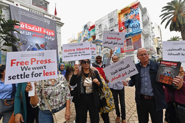 Tunisian journalists hold signs during a protest demanding press freedom outside the National Syndicate of Tunisian Journalists (SNJT) in Tunis on May 5, 2022. - Tunisia has dropped 21 places in the World Press Freedom index for the year 2022, from 73rd to 94th place out of 180 countries. The index is published by Reporters Without Borders (RSF) to assess the state of journalism across the globe. (Photo by FETHI BELAID / AFP)