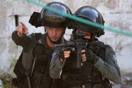 Israeli soldiers takes aim during a raid at house in the town of Rummanah, near the flashpoint town of Jenin in the occupied West Bank on May 8, 2022, reportedly the home of Palestinian Subhi Imad Abu Shukair, suspected of carrying out a fatal axe attack in the central city of Elad two days earlier. - Two Palestinians suspected of killing three Israelis in an axe attack in Elad were arrested after a more than two day manhunt, the security services said. (Photo by JAAFAR ASHTIYEH / AFP)