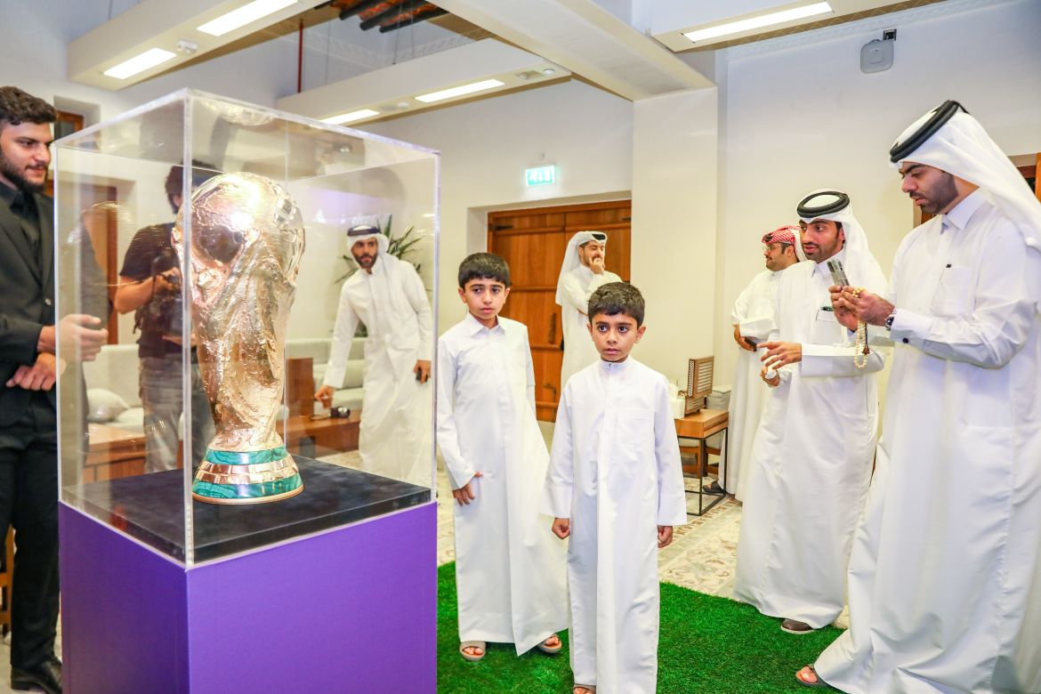 طفلان قطريان يتطلعان لمونديال قطر عبر التقاط صورة تذاكرية مع الكأس - الجزيرة نت
