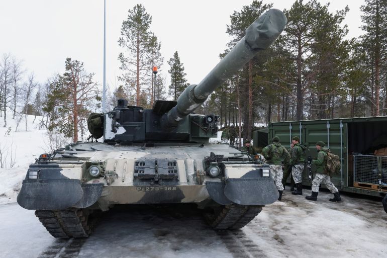 Finnish soldiers stand next to a tank during a military exercise called "Cold Response 2022", gathering around 30,000 troops from NATO member countries plus Finland and Sweden, amid Russia's invasion of Ukraine, in Evenes, Norway, March 22, 2022. REUTERS/Yves Herman