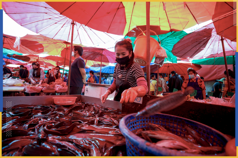 epa08934296 A woman wearing a protective face mask prepares fish for sale at a wet market stall in Bangkok, Thailand, 13 January 2021. Thailand's economy, one of the worst hit economies in Asia, is expected to grow slower than earlier predictions due to the new wave of COVID-19 coronavirus pandemic which continues to impact both the local consumer spending as well as the tourism industry. EPA-EFE/DIEGO AZUBEL