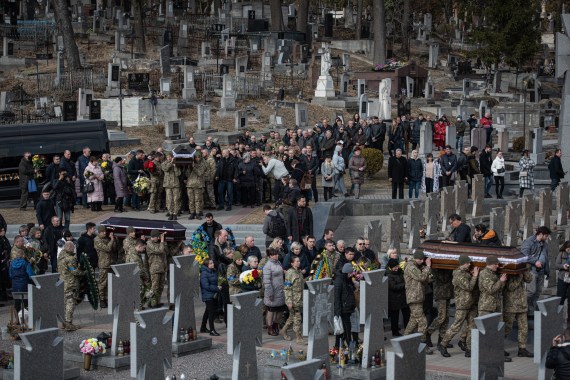LVIV, UKRAINE - MARCH 15: Ukrainian servicemen carry coffins during the funeral service for Oleh Yaschyshyn, Sergiy Melnyk, Rostyslav Romanchuk and Kyrylo Vyshyvany in Lychakivske cemetery on March 15, 2022 in Lviv, Ukraine. The men died in Sunday's airstrike on the nearby International Center for Peacekeeping and Security at the Yavoriv military complex. The barrage of Russian missiles killed 35 and wounded scores. The site, west of Lviv in the town of Starychi, is mere miles from Ukraine's border with Poland. (Photo by Alexey Furman/Getty Images)