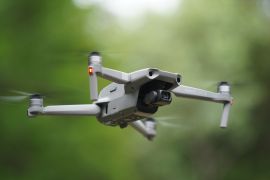 NEW HAMPSHIRE, USA - May 28, 2020: DJI Mavic Air 2 drone hovering in the air. Small gray folding quadcopter with camera in flight.