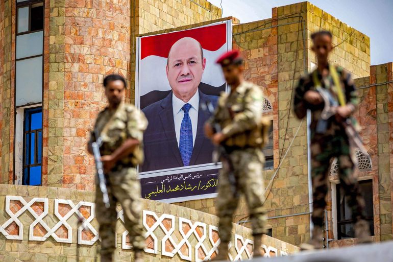 Soldiers loyal to the Aden-based Yemeni government stand guard before a poster showing the chairman of the presidential council Rashad al-Alimi, while on guard duty during a demonstration demanding the end of a years-long siege imposed by the Huthi rebels on the third city of Taez on May 25, 2022. Talks brokered by the UN to end the siege started in Jordan on May 25. Holding the talks was conditional to end the blockade as part of a two-month renewable truce that began in April and which has significantly reduced fighting in the seven-year civil war. Taez, which has a population of roughly 600,000 people, has been largely cut off from the world since 2015 when the rebels closed the main routes into the city. AHMAD AL-BASHA / AFP