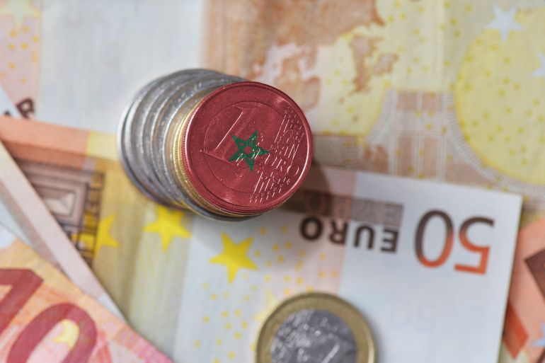 euro coin with national flag of morocco on the euro money banknotes background. finance concept
