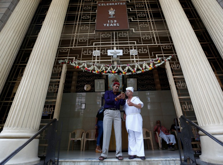 A Parsi man speaks to a priest at a fire temple during the Parsi New Year day in Mumbai