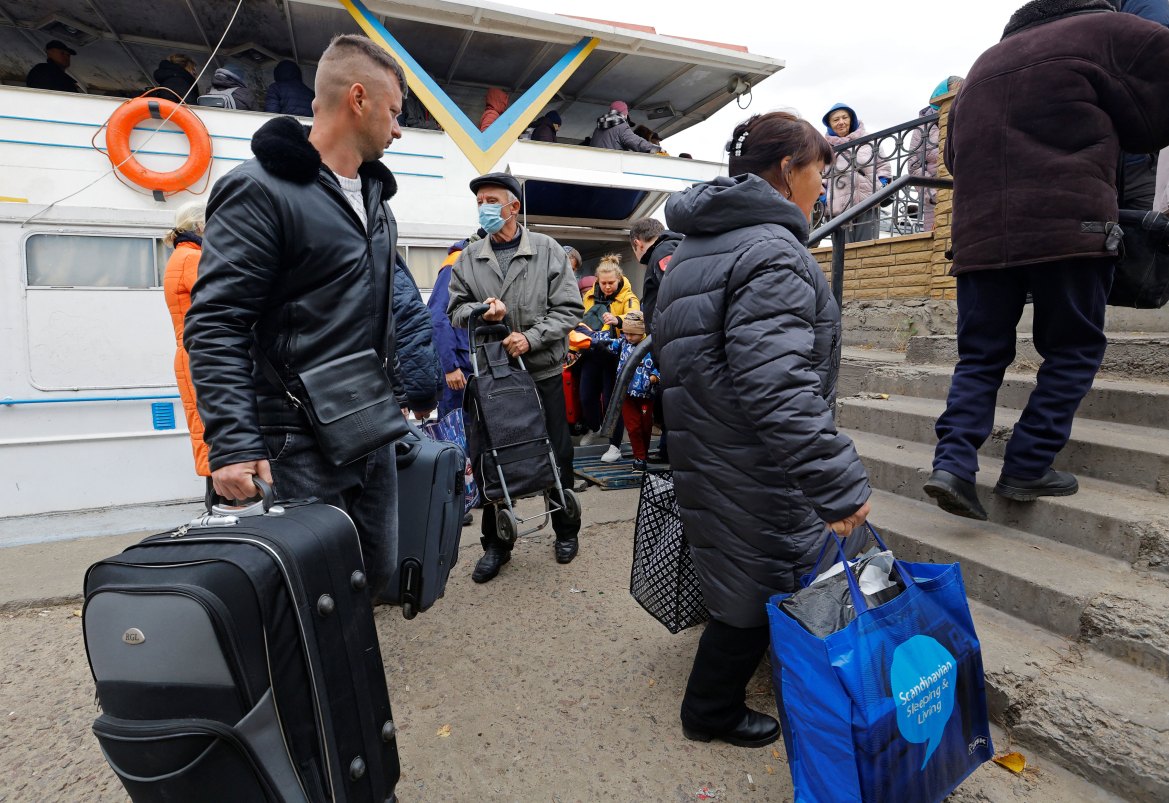 Civilians evacuated from the Russian-controlled city of Kherson disembark a ferry as they arrive in the town of Oleshky, Kherson region, Russian-controlled Ukraine. [Alexander Ermochenko/Reuters]