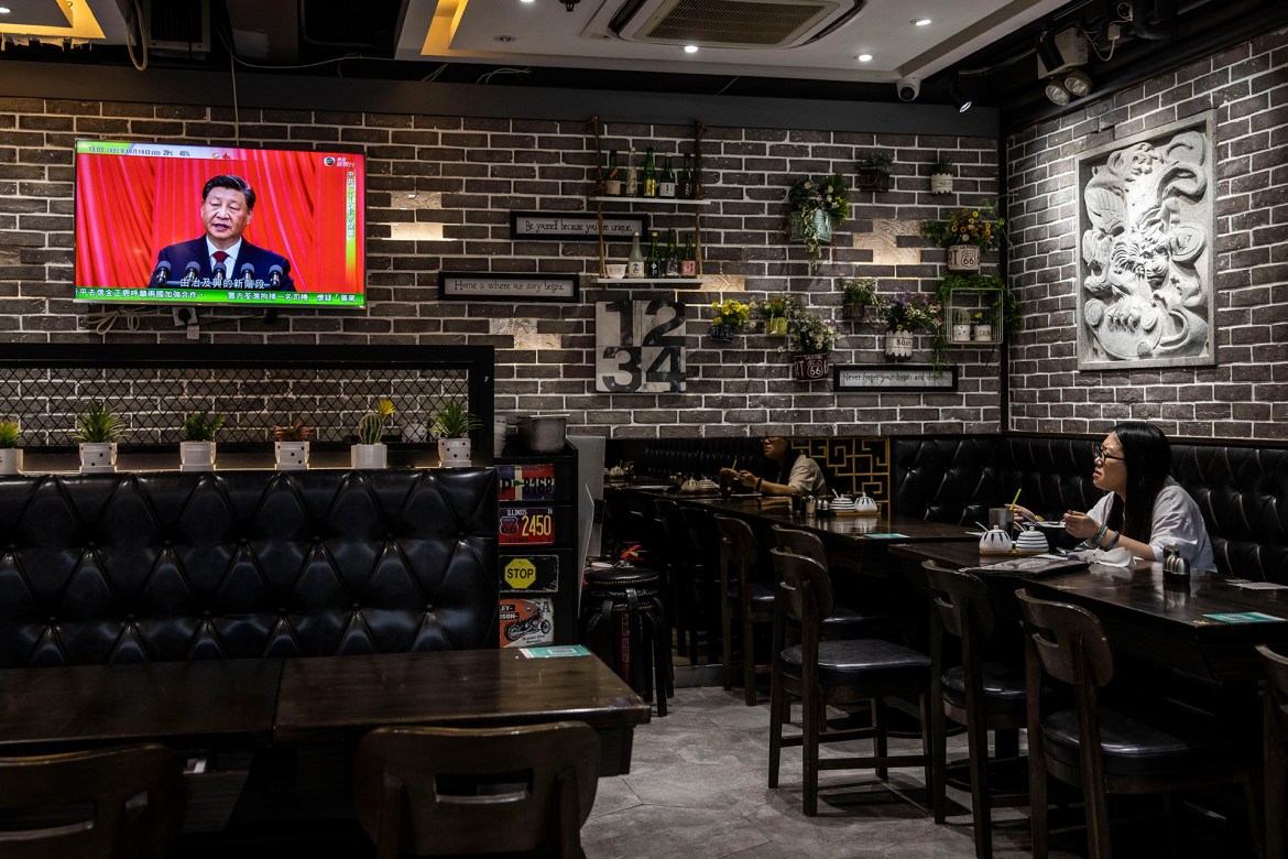 Chinese President Xi Jinping is seen on a TV screen in a restaurant in Hong Kong as he delivers the opening speech of the ruling Communist Party's 20th congress in Beijing. [Isaac Lawrence/AFP]