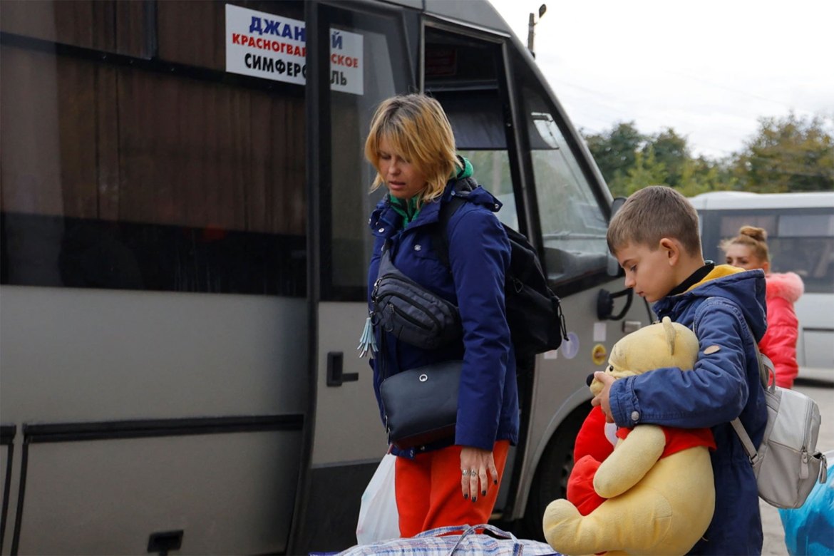 Civilians evacuated from Kherson wait to board a bus heading to Crimea, in the town of Oleshky. [Alexander Ermochenko/Reuters