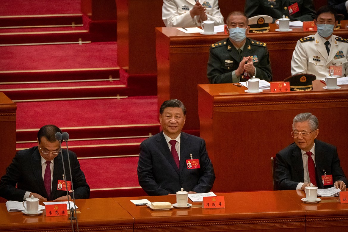 China's President Xi Jinping, centre, sits after addressing the Congress. [Mark Schiefelbein/AP Photo]