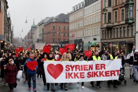 Demonstrators march with a banner reading 'Syria is not safe' during a protest against the deportation of Syrian families to their homeland in Copenhagen on November 13, 2021. - Their lives are paused in a never-ending wait: Bilal Alkale and his family are among the hundreds of Syrian refugees in Denmark whose temporary residency permits have been revoked -- but they can't be deported and now they have no rights. (Photo by Thibault Savary / AFP)