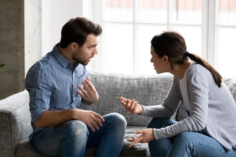 Hangsúlyozta a fiatal házaspár érzelmileg vitatkozott, hibáztatva egymást, ül a kanapén. Depressziós férj veszekedés feleségével, amelynek komoly kapcsolatok kommunikációs problémák.