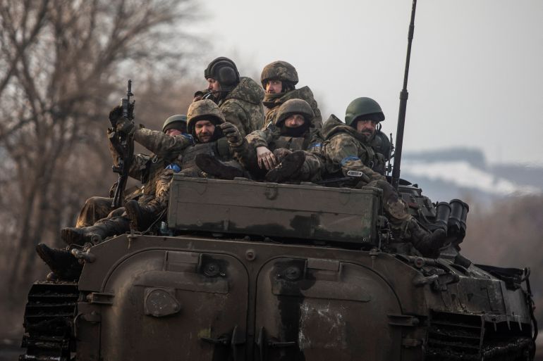 Ukrainian servicemen sit atop a BMP-2 infantry fighting vehicle on a road outside the frontline town of Bakhmut